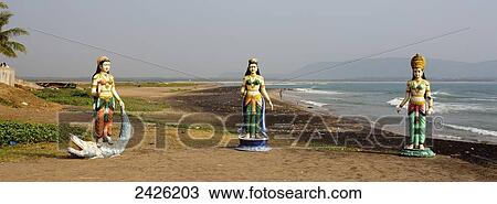 Stock Image - Statues of indian women on the beach at the water's edge; Visakhapatnam, Andhra Pradesh, India. Fotosearch
