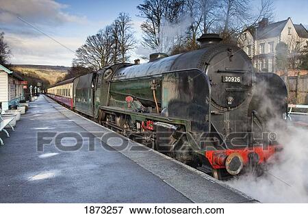 Steam From A Train Along The Tracks At A Station; Grosmont, North Yorkshire, England View Large Photo Image Stock Photo - Steam From A Train Along The Tracks At A Station; Grosmont, North Yorkshire, England. Fotosearch