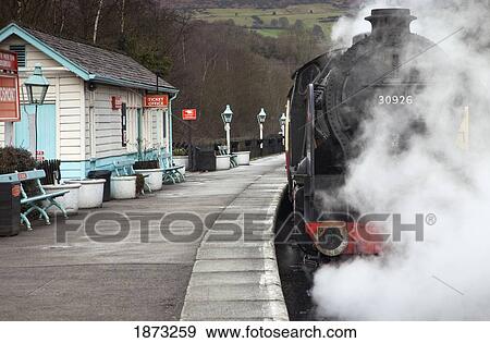 Steam From A Train Along The Tracks At A Station; Grosmont, North Yorkshire, England View Large Photo Image Stock Photo - Steam From A Train Along The Tracks At A Station; Grosmont, North Yorkshire, England. Fotosearch