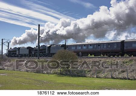 Stock Image - Steam From A Train As It Moves Along The Tracks; Northumberland, England. Fotosearch
