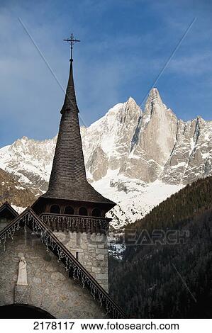 Steeple Of A Church With A Cross On Top And Mountains In The Background Against A Blue Sky; Chamonix-Mont-Blanc Rhone-Alpes France View Large Photo Image Stock Photo - Steeple Of A Church With A Cross On Top And Mountains In The Background Against A Blue Sky; Chamonix-Mont-Blanc Rhone-Alpes France. Fotosearch