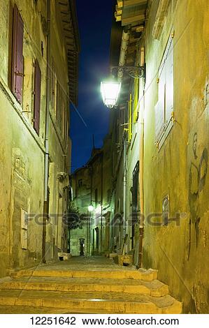 Steps between two buildings illuminated at night; Arles, Provence-Alpes-Cote D'Azur, Bouches-Du-Rhone, France View Large Photo Image Stock Image - Steps between two buildings illuminated at night; Arles, Provence-Alpes-Cote D'Azur, Bouches-Du-Rhone, France. Fotosearch