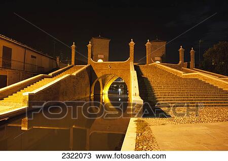 Stone bridge with towers and steps reflecting in water, night; Comacchio, Emilia-Romagna, Italy View Large Photo Image Stock Image - Stone bridge with towers and steps reflecting in water, night; Comacchio, Emilia-Romagna, Italy. Fotosearch