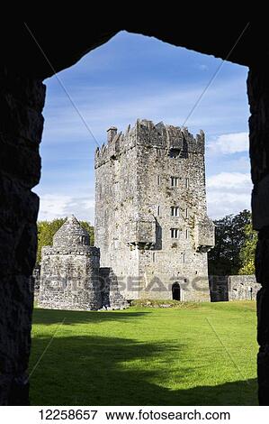 Stock Photo - Stone castle framed in a silhouetted entrance way with blue sky; County Galway, Ireland. Fotosearch