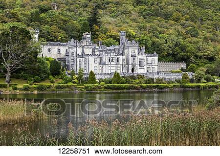 Stock Image - Stone castle reflecting in lake with treed hillside; County Galway, Ireland. Fotosearch