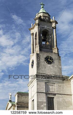 Stock Photo - Stone church steeple and bell tower with clouds and blue sky; Athlone, County Westmeath, Ireland. Fotosearch