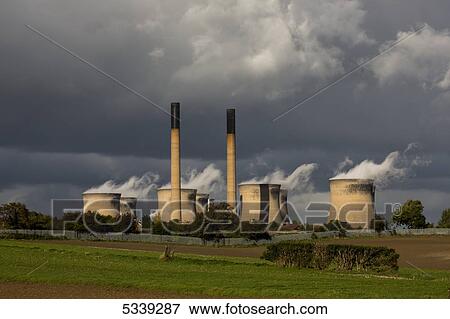 Stock Photo - Storm clouds over chimneys and structures with emissions; Yorkshire, England. Fotosearch