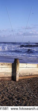 Stock Image - Stormy Sea Hitting Groynes On Beach. Fotosearch