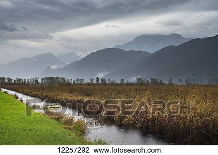 Stock Image - Stormy weather and rain descends on the mountains around Pitt Lake; Pitt Meadows, British Columbia, Canada. Fotosearch