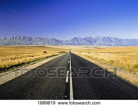 Stock Photo - Straight Road Between Fields. Fotosearch