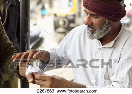 Stock Image - Street media applies medicine; Jodhpur, Rajasthan, India. Fotosearch