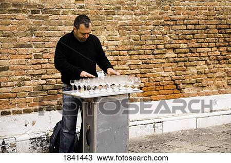 Stock Image - Street Performer Arranging Wineglasses; Venice, Italy. Fotosearch