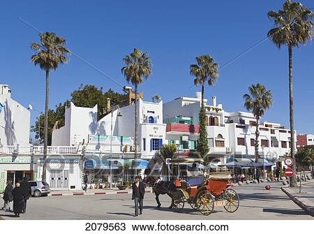 Stock Image - Street Scene With Horse And Carriage In Plaza Zelaka; Asilah Morocco. Fotosearch