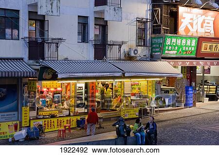 Stock Image - Street Scene With Illuminated Food Shop. Fotosearch