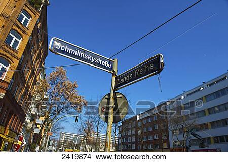 Picture - Street signs at an intersection with buildings and blue sky; Hamburg, Germany. Fotosearch