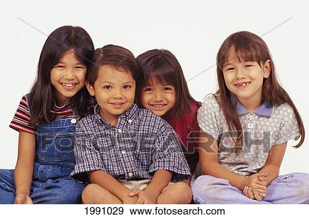 Stock Photo - Studio Shot Of Four Young Local Kids, All Smiling, White Background, Sitting Down. Fotosearch