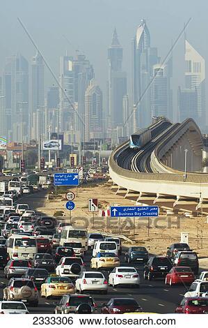Stock Photograph - Subway Train Going Past Traffic; Sheikh Zayed Road, Dubai, United Arab Emirates. Fotosearch