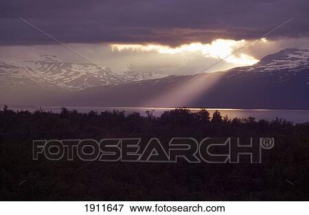 Stock Photo - Sun Breaking Through Overcast Sky, Abisko, Sweden. Fotosearch