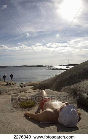 Stock Photo - Sunbathing at Saltholmen near Gothenburg; Sweden. Fotosearch