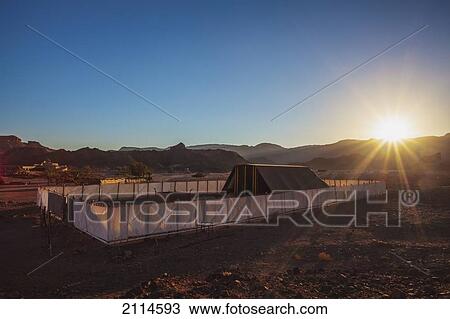 Stock Image - Sunburst Over The Replica Of The Tent Of Meeting And The Brazen Altar; Timna Park Arabah Israel. Fotosearch