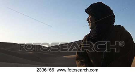 Sunlight Shines In The Face Of A Man As He Looks Over The Erg Chegaga Dunes; Souss-Massa-Draa, Morocco View Large Photo Image Stock Photograph - Sunlight Shines In The Face Of A Man As He Looks Over The Erg Chegaga Dunes; Souss-Massa-Draa, Morocco. Fotosearch