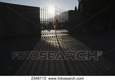 Sunlight Shining Through A Metal Gate With A Cross On Top; Bellinzona, Ticino, Switzerland View Large Photo Image Stock Image - Sunlight Shining Through A Metal Gate With A Cross On Top; Bellinzona, Ticino, Switzerland. Fotosearch