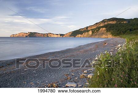 Stock Image - Sunrise On A Beach And Cliffs Along The Water; Quebec Canada. Fotosearch