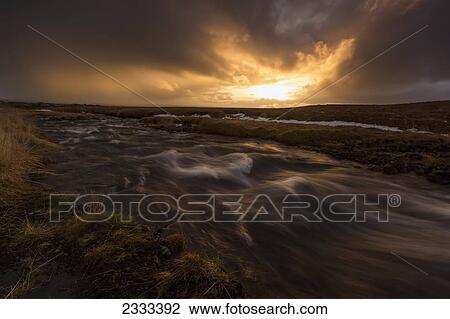 Stock Image - Sunrise Over A Flowing Stream; Snaefellsnes Peninsula, Iceland. Fotosearch