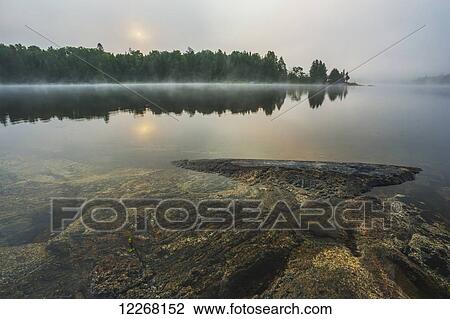 Sunrise over a tranquil lake; Ontario, Canada View Large Photo Image Stock Image - Sunrise over a tranquil lake; Ontario, Canada. Fotosearch