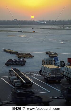 Stock Photo - Sunrise Over The Equipment On The Beijing Airport Tarmac; Beijing Thailand. Fotosearch