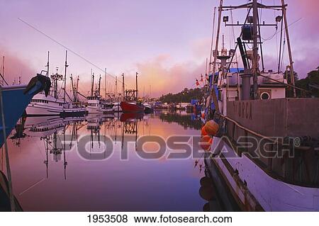 Stock Photo - Sunrise Through The Morning Fog And Fishing Boats In Newport Harbor; Newport Oregon United States Of America. Fotosearch