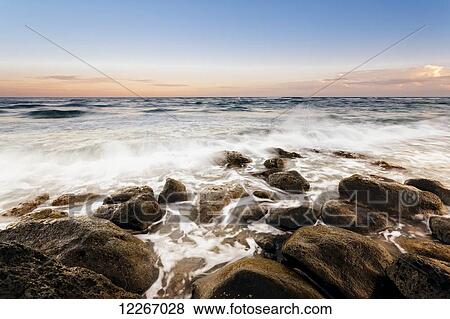 Sunset and surf along rocks, Lydgate Beach; Wailua, Kauai, Hawaii, United States of America View Large Photo Image Stock Photo - Sunset and surf along rocks, Lydgate Beach; Wailua, Kauai, Hawaii, United States of America. Fotosearch