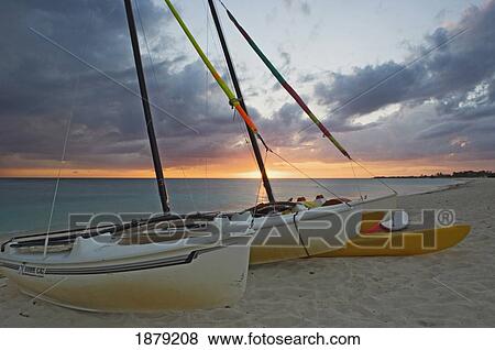 Sunset At Playa Ancon Beach Near Trinidad With Beached Sail Boats In The Foreground. View Large Photo Image Stock Photo - Sunset At Playa Ancon Beach Near Trinidad With Beached Sail Boats In The Foreground.. Fotosearch