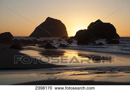 Stock Image - Sunset behind rocks, at Tolowa Dune State Park, Northern California Coast; California, United States of America. Fotosearch