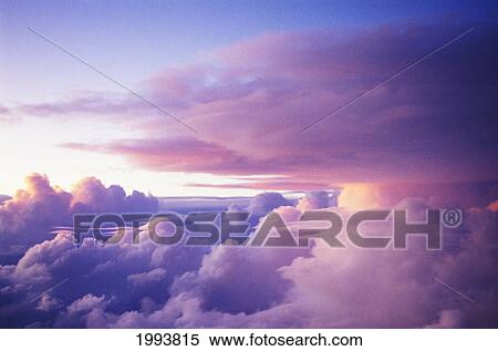 Sunset Clouds Viewed From The Window Of A Commercial Airplane. View Large Photo Image Stock Photography - Sunset Clouds Viewed From The Window Of A Commercial Airplane.. Fotosearch
