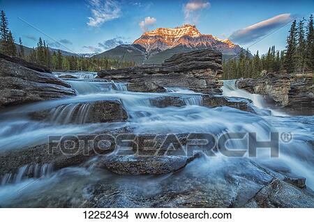 Sunset lights up Mount Fryatt as the Athabasca River flows over Athabasca Falls in Jasper National Park; Alberta, Canada View Large Photo Image Picture - Sunset lights up Mount Fryatt as the Athabasca River flows over Athabasca Falls in Jasper National Park; Alberta, Canada. Fotosearch