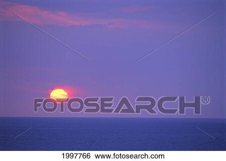 Stock Photograph - Sunset Over Calm Ocean, Sun Ball In Purple Sky, Vog (Volcanic Smog) Horizon A29G. Fotosearch