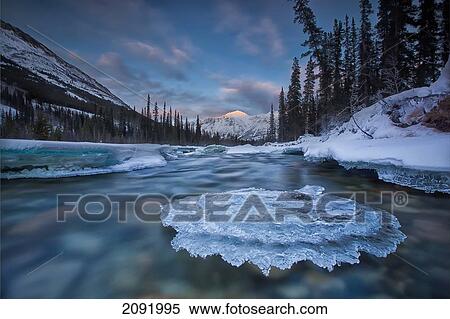 Sunset Over Ice-Covered Rock In Wheaton River; Yukon Canada View Large Photo Image Stock Photography - Sunset Over Ice-Covered Rock In Wheaton River; Yukon Canada. Fotosearch