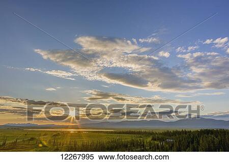 Stock Photography - Sunset over the Baird Mountains, forest and green tundra near the village of Shungnak, Arctic Alaska, summer, HDR. Fotosearch