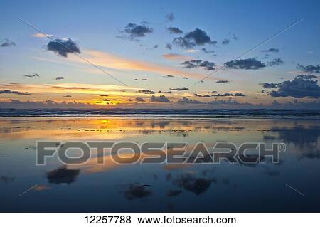 Stock Photo - Sunset reflecting in the Pacific Ocean along Ocean Shores, Washington, USA. Fotosearch