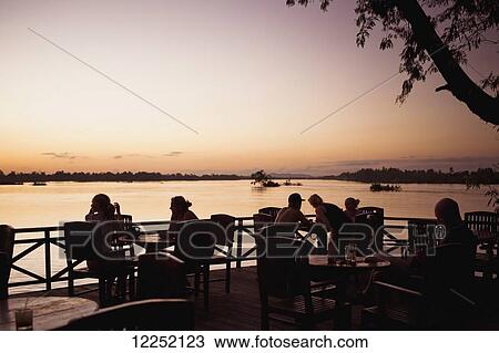 Sunset viewed from a restaurant's outdoor patio on the water; Laos View Large Photo Image Stock Image - Sunset viewed from a restaurant's outdoor patio on the water; Laos. Fotosearch