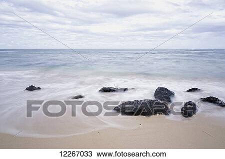 Stock Image - Surf washing up along the beach; Wailua, Kauai, Hawaii, United States of America. Fotosearch