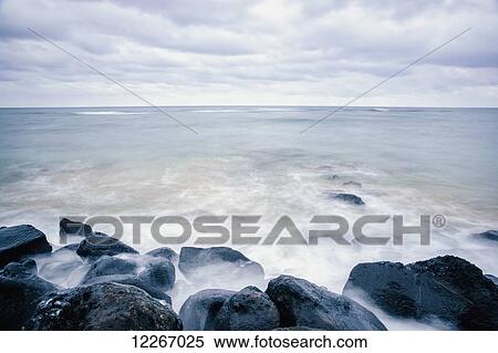 Stock Photography - Surf washing up around rocks; Wailua, Kauai, Hawaii, United States of America. Fotosearch