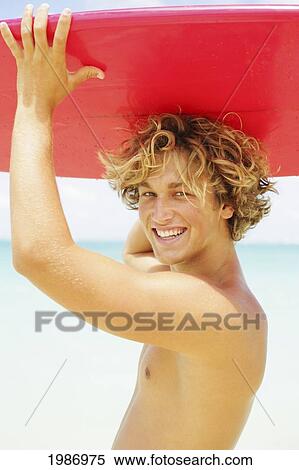 Surfer Boy Holding A Red Surfboard Over His Head On A Warm Tropical Beach. View Large Photo Image Stock Photography - Surfer Boy Holding A Red Surfboard Over His Head On A Warm Tropical Beach.. Fotosearch