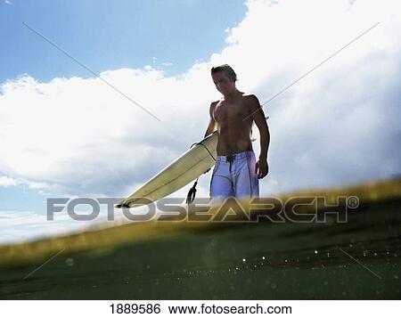 Surfer Carrying Board Into Sea, Split Level View Large Photo Image Stock Photograph - Surfer Carrying Board Into Sea, Split Level. Fotosearch