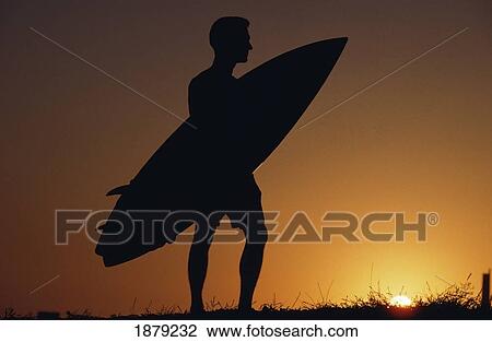 Stock Image - Surfer In Silhouette Holding A Surf Board. Fotosearch