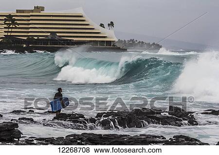 Surfer observing large waves near Royal Kona Resort; Kailua-Kona, Island of Hawaii, Hawaii, United States of America View Large Photo Image Stock Photo - Surfer observing large waves near Royal Kona Resort; Kailua-Kona, Island of Hawaii, Hawaii, United States of America. Fotosearch