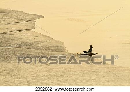 Stock Image - Surfer On Empty Beach; Byron Bay, New South Wales, Australia. Fotosearch