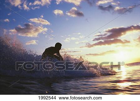 Surfer Riding Small Whitewater Wave At Sunset. View Large Photo Image Picture - Surfer Riding Small Whitewater Wave At Sunset.. Fotosearch