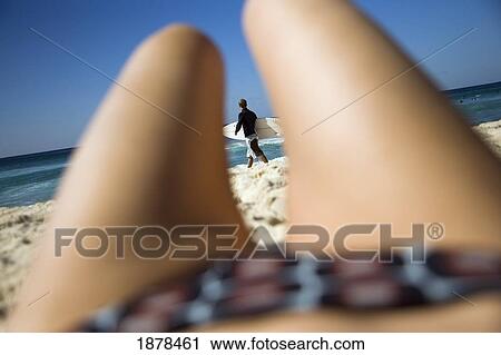 Surfer Viewed Through Womans Legs Lying On Bondi Beach View Large Photo Image Stock Image - Surfer Viewed Through Womans Legs Lying On Bondi Beach. Fotosearch